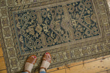 Lower right corner of antique Perpedil Caucasian rug showing geometric border and tattered ends.