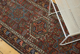 Karaja runner border detail: dark blue meandering leaf motif on cherry red field.