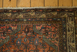 Vintage Persian Tajabad rug corner: finely woven floral motifs in brick red, sky blue, green.