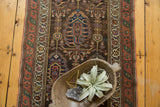 Antique Northwest Persian runner, charcoal field with repeating germinating boteh motifs in teal and red.
