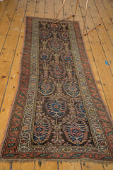 Antique Northwest Persian rug's boteh motifs, madder red border, and visible knot head wear.