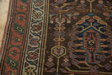 Close-up of antique Northwest Persian runner's madder border, charcoal field, and worn texture.
