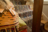 Antique Northwest Persian runner's repeating boteh motif with germinating plants in charcoal brown and jewel tones.