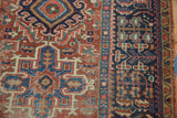 Hand-knotted Karaja rug's brick red field with geometric leaves, wear, and navy blue border.
