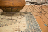 Antique Persian Doroksh rug close-up: navy and sky blue geometric border, distressed ivory field.