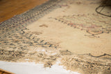 Tattered edge and extensive pile loss exposing light foundation on an antique Doroksh rug.