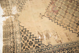 Extensive tatter revealing beige foundation and faded floral design of antique Doroksh rug.
