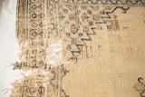 Extensive tatter, exposed foundation, and reweaving on an antique Doroksh rug's field.