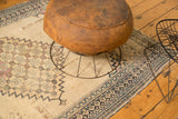 Aged texture of an antique Persian Doroksh rug with ivory field, navy border, and floral motifs.
