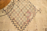 Antique Doroksh rug with ivory, blue, mauve geometric pattern, revealing wear and storied repairs.
