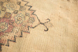 Extensively worn surface of an antique Doroksh rug, revealing beige foundation and fragmented pattern.