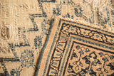 Tattered beige foundation and patterned corner of an antique Doroksh rug.
