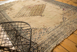 Extensive tatter on an antique Doroksh rug with ivory field and navy border patterns.