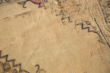 Extensively tattered beige foundation and remnant pattern on an antique Doroksh rug.