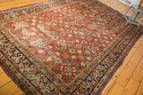 Angled corner of vintage Mahal rug, cherry red field with pomegranate florals, navy border.
