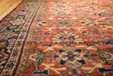 Vintage Mahalati carpet detail with terra cotta rust field, navy border, and sage floral motifs.