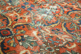 Localized distress and exposed foundation on a vintage Mahal carpet's floral field.