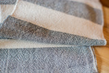 Textured black and cream stripes on a folded handwoven dish towel.