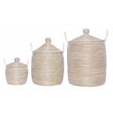Varying sizes of minimalist lidded seagrass baskets in natural tones, medium basket centered.