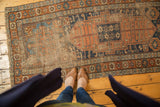 Antique Kurdish runner, terra cotta and indigo field with evident foundation wear, starburst motifs.