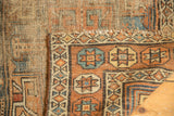 Antique Kurdish rug corner detail reveals geometric borders, coarse foundation, and tattered edge.