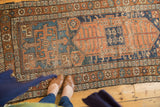Antique Kurdish rug corner: geometric borders and asymmetric field in indigo and terra cotta.