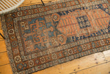Antique Kurdish rug detail: oblong medallion, geometric patterns, indigo, terra cotta, coffee brown.