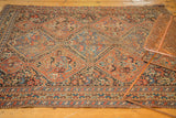 Vintage Kamseh rug's geometric panel design and stylized border with aged edge.