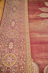 Worn vintage Amritsar carpet border detail with wine red and ivory cartouche and pomegranate motifs.