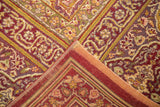 Vintage Amritsar carpet detail: wine red, mauve, green border, cartouche pattern, worn pile, machine binding.