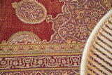 Wine red vintage Amritsar carpet detail with mauve curvilinear floral motifs and repeating border.