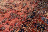 Detail of the antique Lilihan carpet's expressive botehs, delicate vinery, and sapphire blue border.