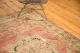 Antique Kerman rug corner with trefoil medallion, blush field, and age-softened texture.