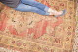 Antique Kerman rug detail, with trefoil motifs, floral palmettes, cochineal red field, and tattered edges.