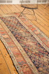 Detail of antique Kurdish Hamadan runner: worn indigo field with rainbow-like boteh motifs and geometric borders.