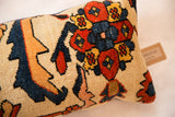 Hand-knotted texture and rich geometric motifs in red, navy, and gold on the rug fragment pillow.