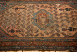 Worn Malayer rug showing dusty rose herati leaves, medallion, and corner spandrel figure.