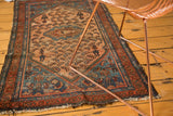 Vintage Malayer rug corner: dusty rose field with man in uniform smoking hookah motif.