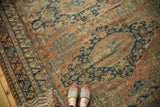 Antique Caucasian Soumac carpet with indigo and faded brick red geometric motifs, showing authentic worn texture.