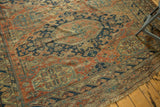 Intricate geometric field and ornate medallions with varied wear on an antique Soumac.