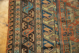 Geometric border bands and flatweave texture in indigo, brick red, and saffron yellow.