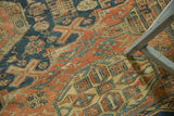 Intricate geometric patterns in indigo blue, brick red, and faded saffron on antique Soumac carpet.