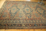 Intricate geometric borders of the antique Caucasian Soumac rug with indigo blue, red, and ivory motifs.