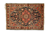 Hand-knotted vintage Hamadan rug, brick red medallion, navy floral field, even wear.
