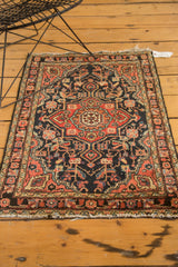 Upper right corner of vintage Persian Hamadan rug, showing floral vinery and fringed end.