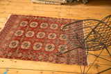 Antique Turkmen rug's triple column gul motif in deep wine red, terra cotta, and navy blue.