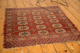 Antique Turkmen square rug with triple column gul motif, wine red, tattered edges.