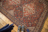 Antique Shiraz rug detail: tribal geometric pattern, stepped contour, red, navy, ivory, wear.