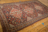 Antique Persian Shiraz tribal carpet corner showcasing geometric patterns, red, navy, and ivory tones.