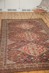Antique Shiraz tribal weaving displaying intricate stepped contours and stylized motifs in red, ivory, and blue tones.